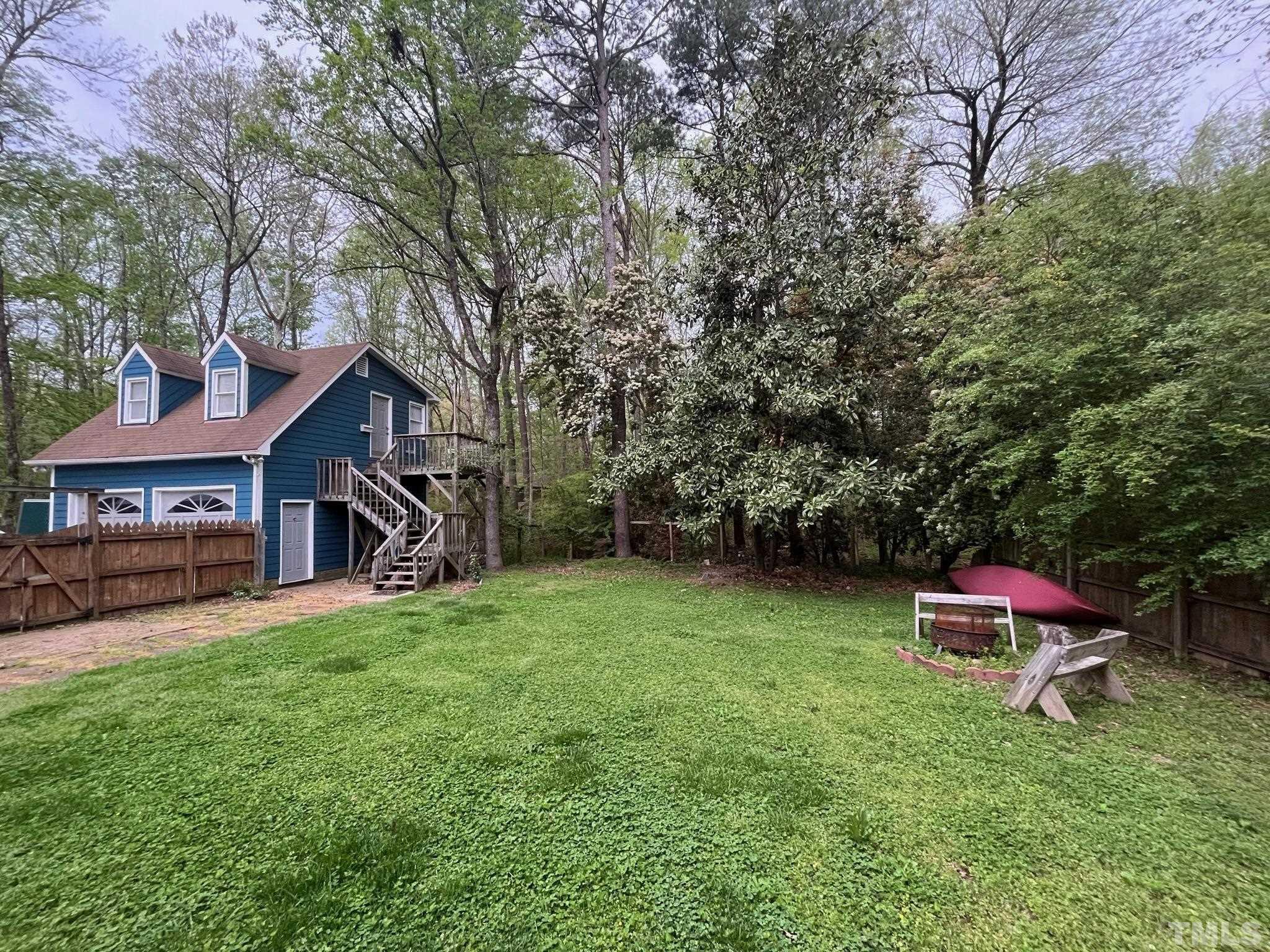 a backyard of a house with table and chairs