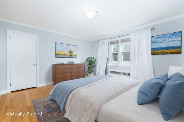 a bedroom with a bed and a painting on the wall