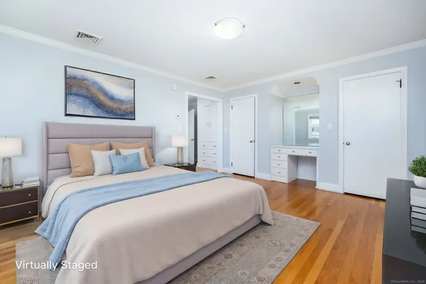 a spacious bedroom with a bed and a painting on the wall