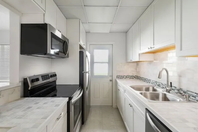 a kitchen with stainless steel appliances granite countertop a sink stove and microwave