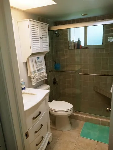 a bathroom with a granite countertop toilet a sink and a shower