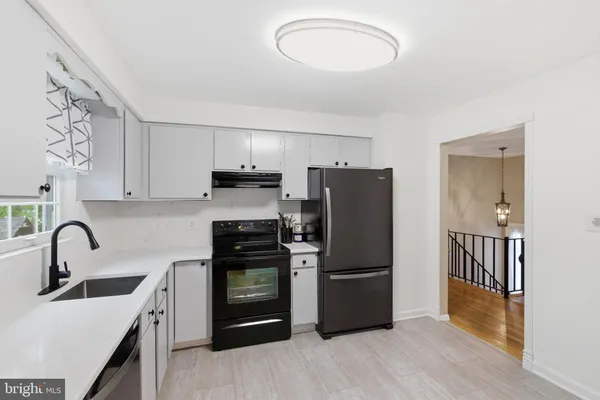 a kitchen with granite countertop a refrigerator and a sink