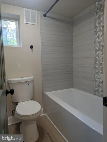 a bathroom with a toilet and bathtub