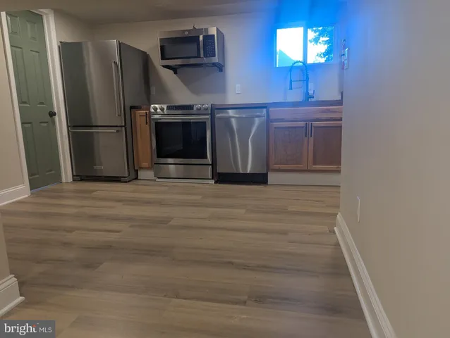 a view of a refrigerator in kitchen and wooden floor