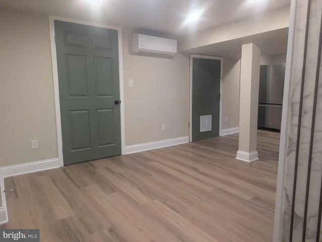 an empty room with wooden floor and entrance