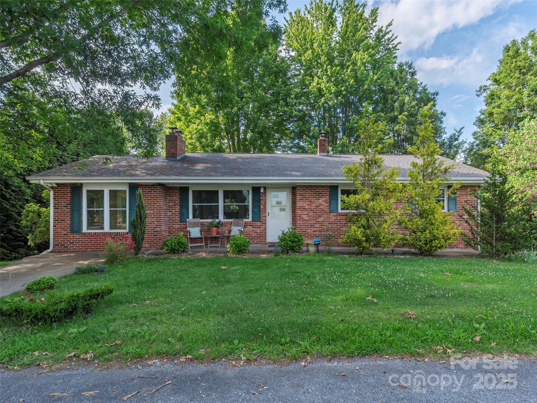 151 Ingram Loop Clyde, NC 28721 - Photo 1 of 30 a front view of a house with a garden and porch