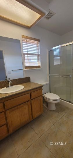 1309 Sims Street Ridgecrest, CA 93555 - Photo 17 of 31 a bathroom with a toilet a sink and mirror