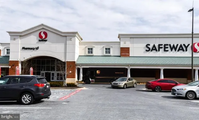 a view of a livingroom with a fireplace a ceiling fan and wooden floor