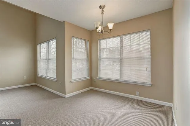 an empty room with windows and chandelier