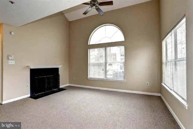 an empty room with a fireplace and windows