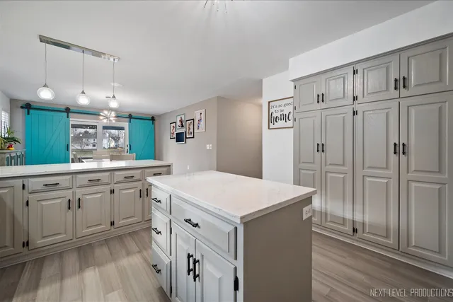 a kitchen with stainless steel appliances a refrigerator and wooden floor