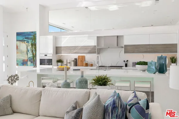 a living room with furniture and a kitchen counter space