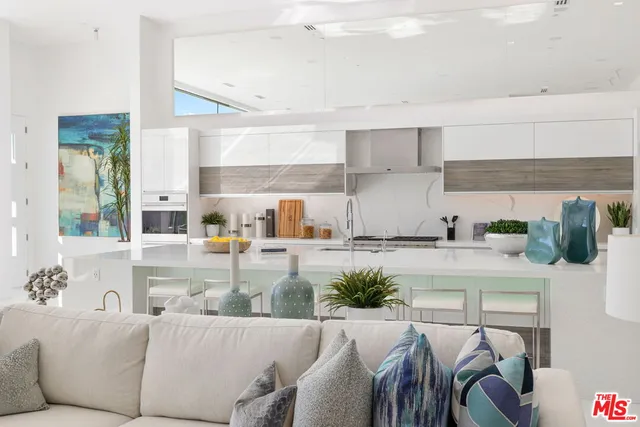 a living room with furniture and a kitchen counter space