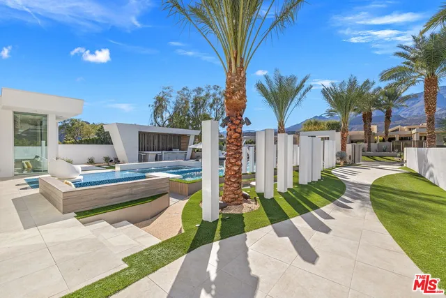 a view of a house with backyard and sitting area
