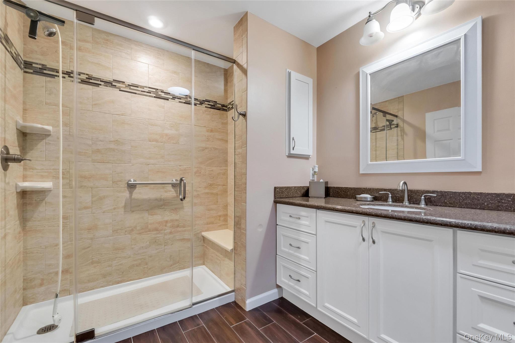 22 Kettle Hole Road Manorville, NY 11949 - Photo 26 of 39 Master bedroom bathroom, tiled shower area w bench seat , and floors. Granite countertop.