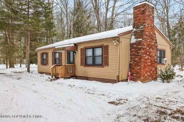 a view of a house with a yard covered in snow