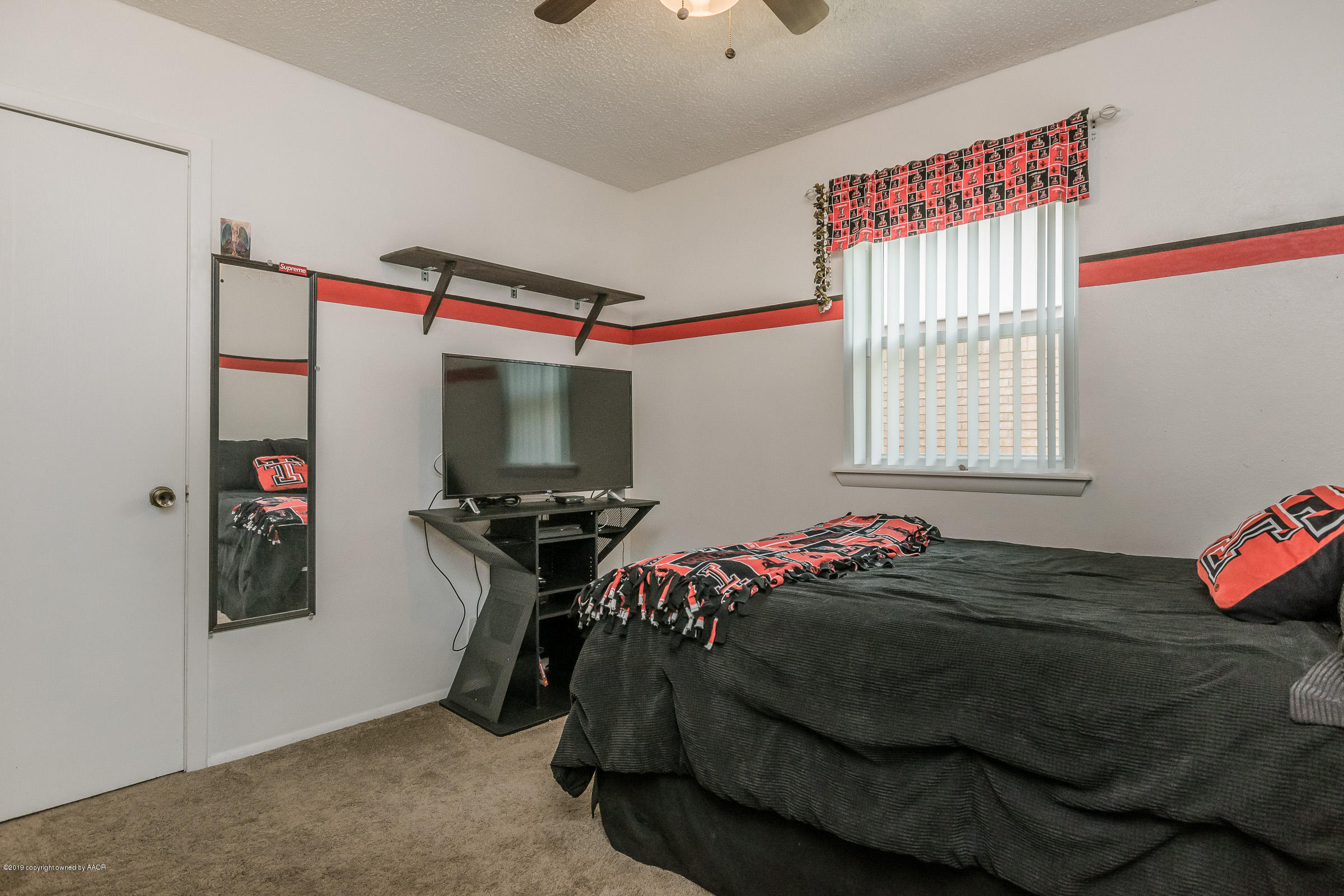 5145 McCarty Boulevard Amarillo, TX 79110 - Photo 16 of 21 a bedroom with a bed and a flat screen tv