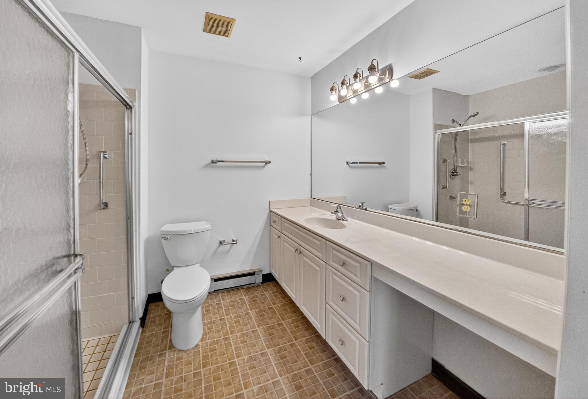 7043 Basswood Road Frederick, MD 21703 - Photo 16 of 34 a spacious bathroom with a granite countertop sink a toilet and a large mirror