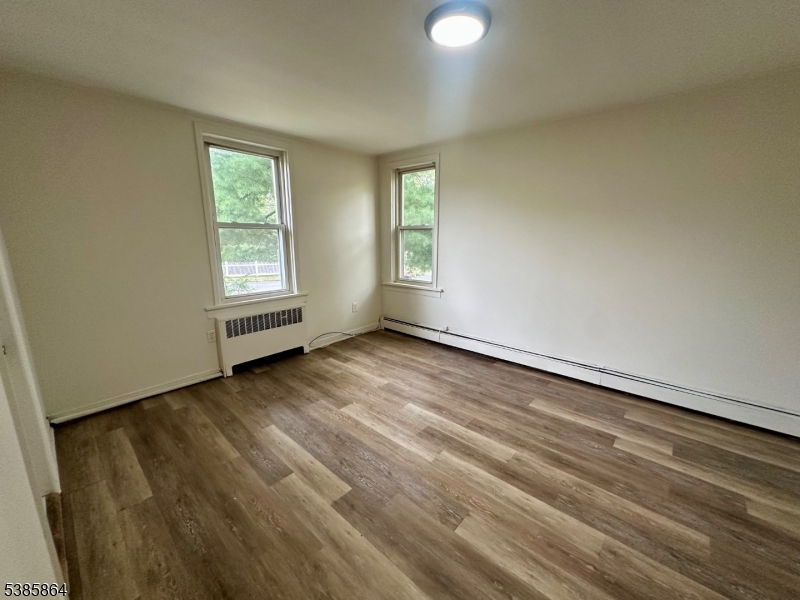 390 Orange Road, Unit 2 Montclair, NJ 07042 - Photo 11 of 16 an empty room with wooden floor and windows