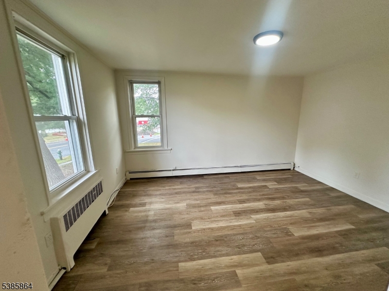 390 Orange Road, Unit 2 Montclair, NJ 07042 - Photo 10 of 16 an empty room with wooden floor and windows