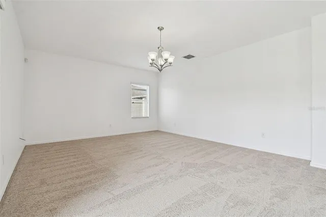 en empty room with windows and chandelier