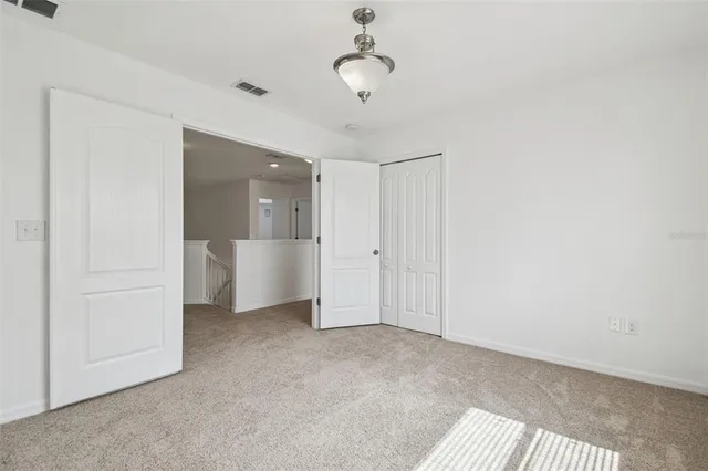 a view of a room with a stylish ceiling fan and entryway
