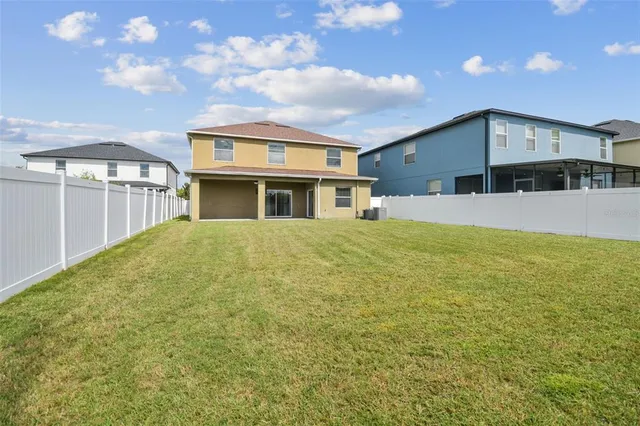 a view of house with yard and sitting area