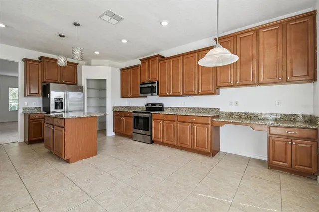 a kitchen with stainless steel appliances granite countertop a stove top oven a sink a counter top space and cabinets