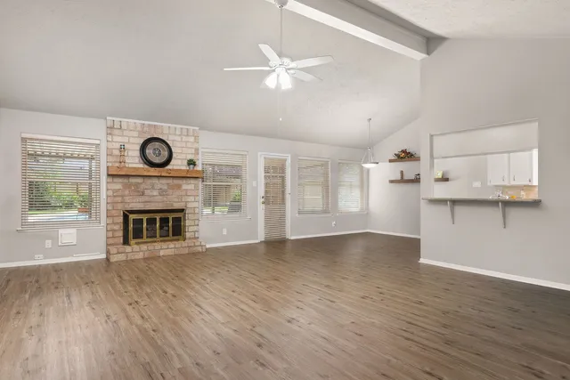 a view of empty room with wooden floor and fireplace