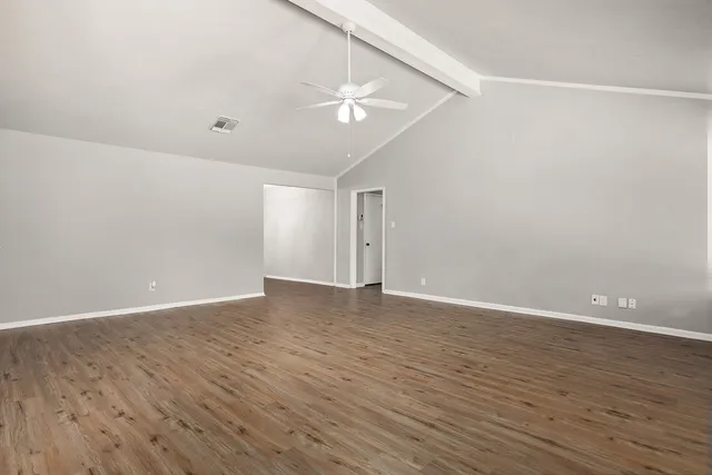 a view of an empty room with wooden floor