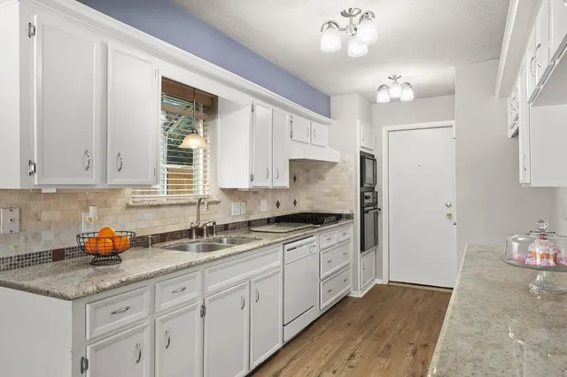 a kitchen with granite countertop a sink cabinets and window