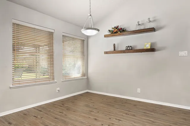 a view of a room with wooden floor and windows