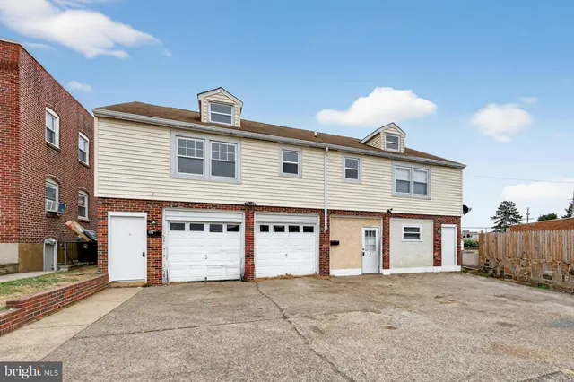 a large tree in front of a white house