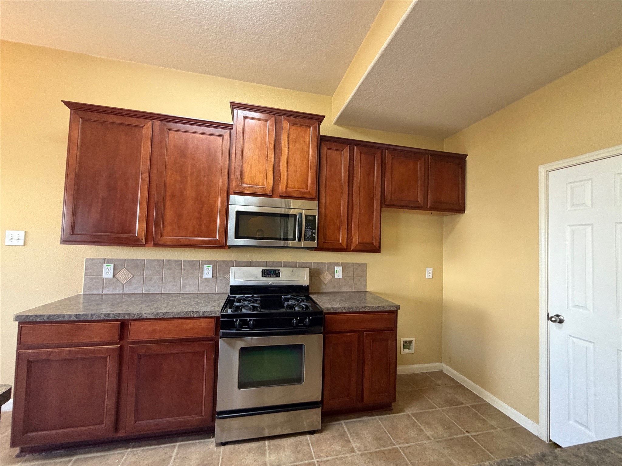 25214 Spring Iris Lane Katy, TX 77494 - Photo 13 of 23 a kitchen with stainless steel appliances granite countertop wooden cabinets a stove top oven a sink and dishwasher