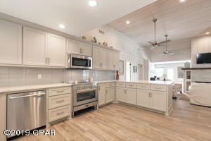 13007 Oleander Drive Panama City Beach, FL 32407 - Photo 6 of 7 a kitchen with stainless steel appliances granite countertop a stove top oven a sink dishwasher and a refrigerator with wooden floor