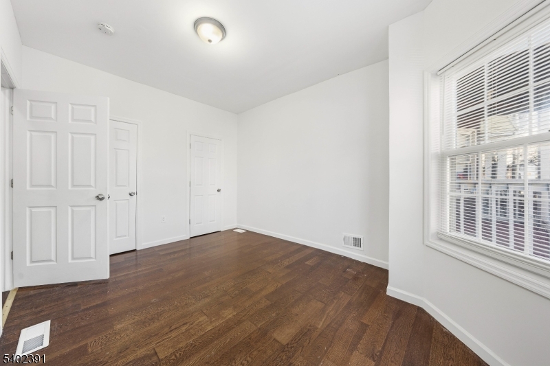 152 South 10th Street Newark, NJ 07107 - Photo 12 of 21 a view of empty room with wooden floor and fan