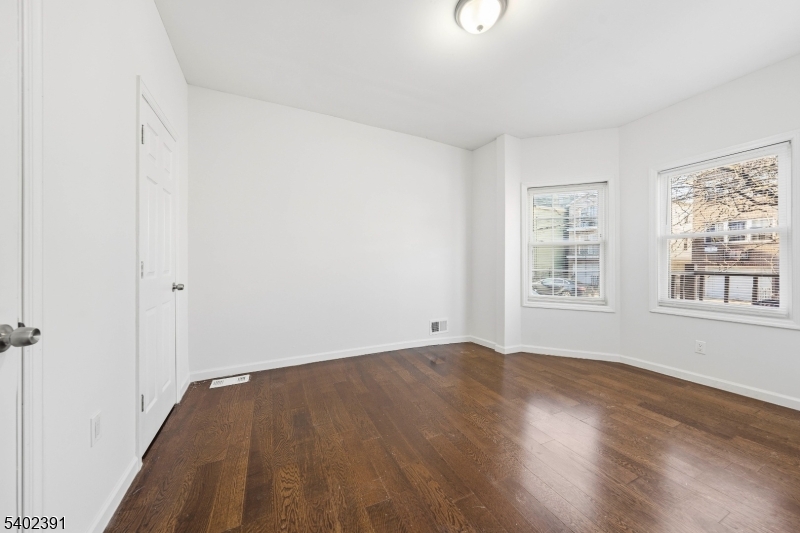 152 South 10th Street Newark, NJ 07107 - Photo 15 of 21 an empty room with wooden floor and windows