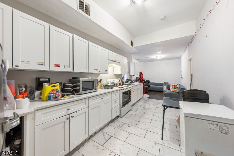 152 South 10th Street Newark, NJ 07107 - Photo 17 of 21 a kitchen with stainless steel appliances granite countertop lots of white cabinets