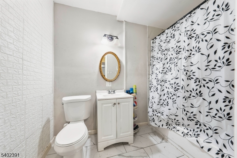 152 South 10th Street Newark, NJ 07107 - Photo 19 of 21 a white toilet sitting next to a shower curtain