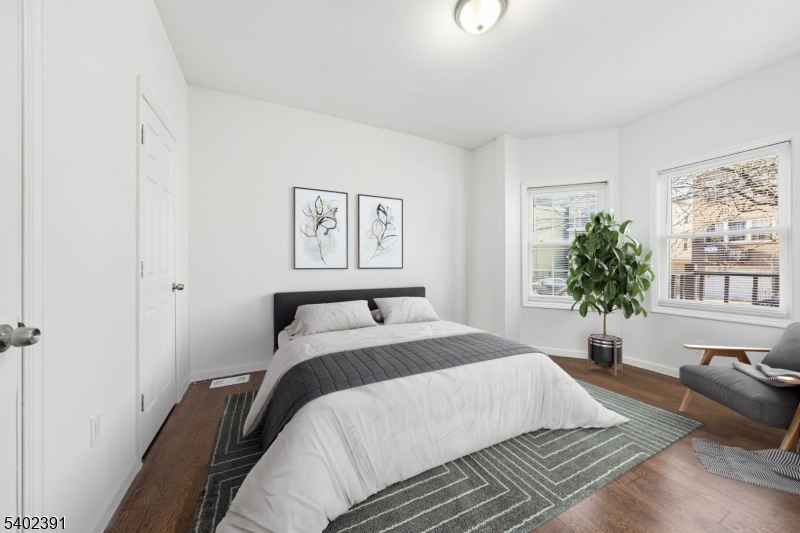 152 South 10th Street Newark, NJ 07107 - Photo 5 of 21 a spacious bedroom with a bed a couch and potted plant