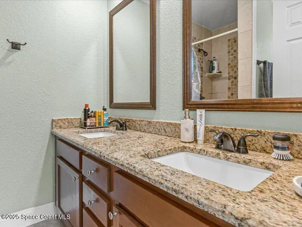 a bathroom with a granite countertop sink and a large mirror