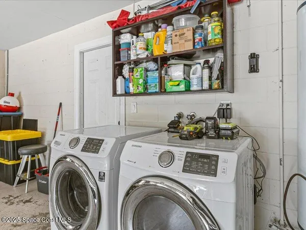 a utility room with dryer washer and a view of living room