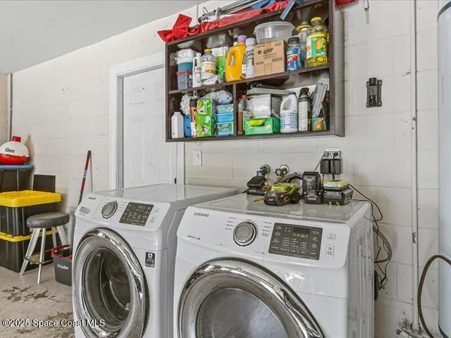 a utility room with dryer washer and a view of living room