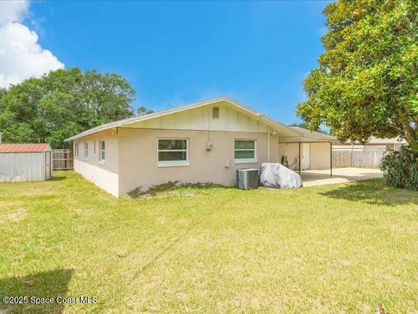a view of a big house with a big yard and large tree