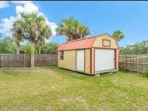 a view of a backyard with brick wall and potted plants
