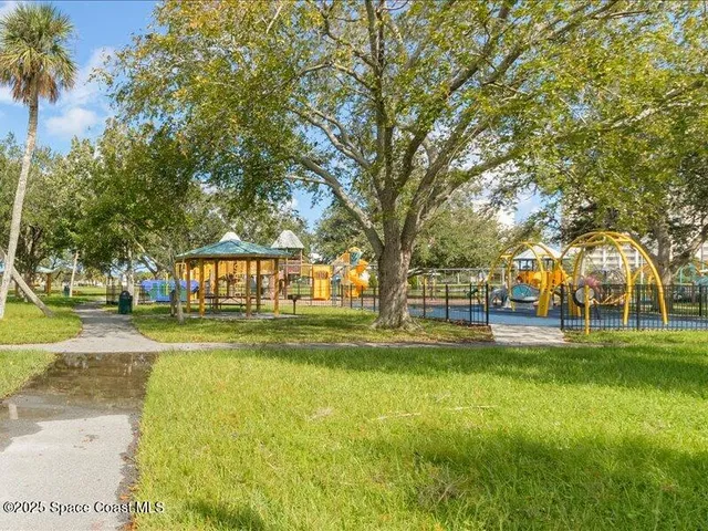 a view of a swimming pool with a lawn chairs under an umbrella