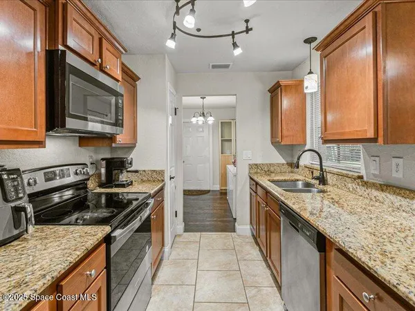 a kitchen with stainless steel appliances granite countertop a sink stove and cabinets