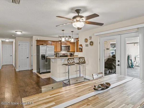 a kitchen with stainless steel appliances kitchen island granite countertop a sink cabinets and wooden floor