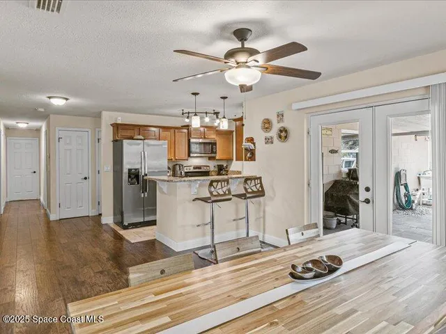 a kitchen with stainless steel appliances kitchen island granite countertop a sink cabinets and wooden floor
