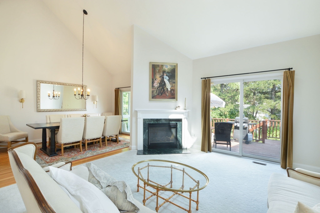 17 Stratford Ridge, Unit 17 Mashpee, MA 02649 - Photo 7 of 24 a living room with furniture a fireplace and a floor to ceiling window